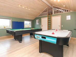 A room with a pool table, a foosball table, a window with a view, and a loft area with a ladder. - 4 Star Holiday Home in Millinge (Millinge)