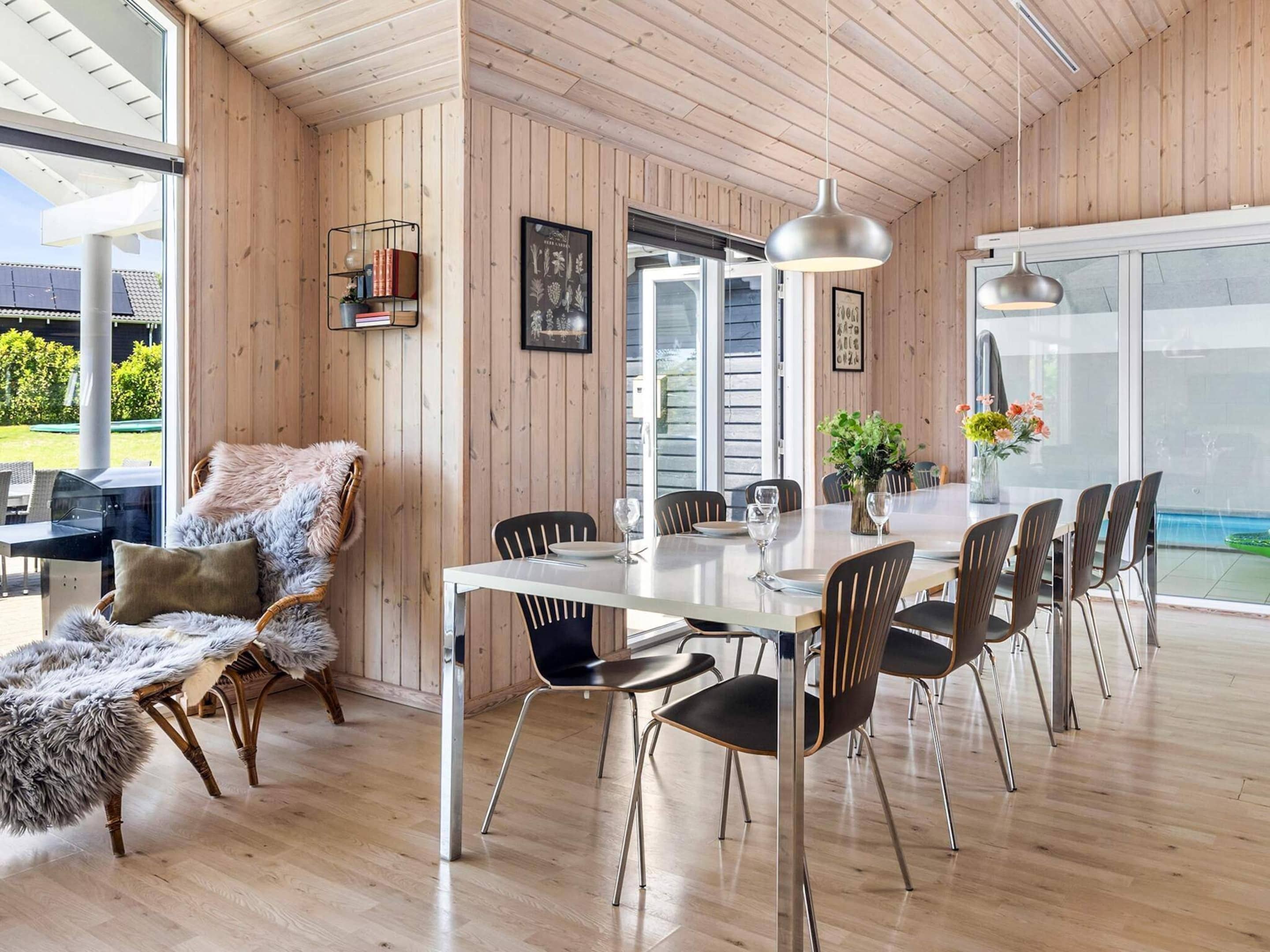A dining area with a wooden interior, a white table, and black chairs.