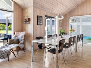 A dining area with a wooden interior, a white table, and black chairs. - 5 Star Holiday Home in Tisvildeleje (Tisvildeleje)