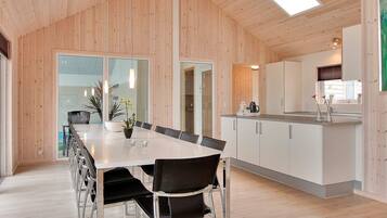 A modern kitchen with white cabinets, a stainless steel countertop, and a skylight.