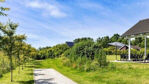 A pathway leading to a building with a covered outdoor seating area.