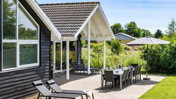 A covered patio with outdoor furniture, a pergola, and a view of the house.