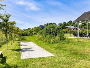 A grassy pathway leading to a building with a covered outdoor seating area. - 5 Star Holiday Home in Tisvildeleje (Tisvildeleje)