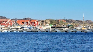 A harbor with red buildings and boats docked. - 8 Person Holiday Home in Lindesnes-by Traum (Lindesnes)