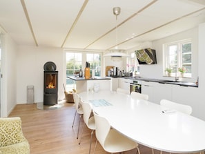 A modern kitchen with a central island, built-in appliances, and a fireplace.