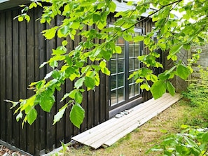 A wooden building with a large window and a wooden deck. - Lovely Holiday Home in Kalundborg near Sea (Kalundborg)