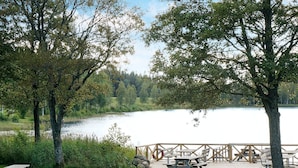 Zona de picnic junto al lago con bancos y mesas de madera.