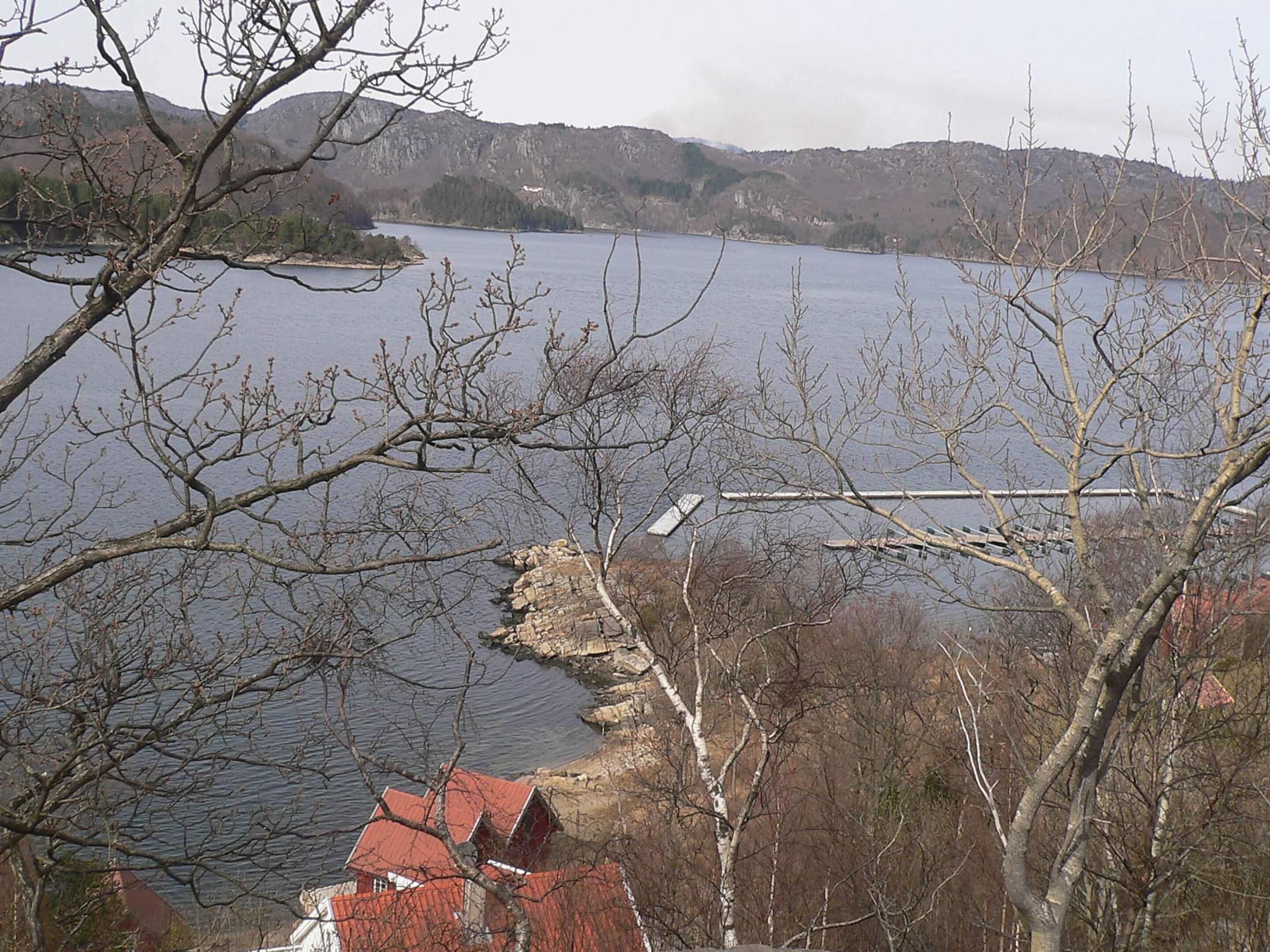 Un lago con una estructura de piedra y edificios en primer plano.