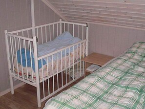 A single room with a bunk bed, a small wooden nightstand, and a plain wall. - 10 Person Holiday Home in Lindesnes (Lindesnes)