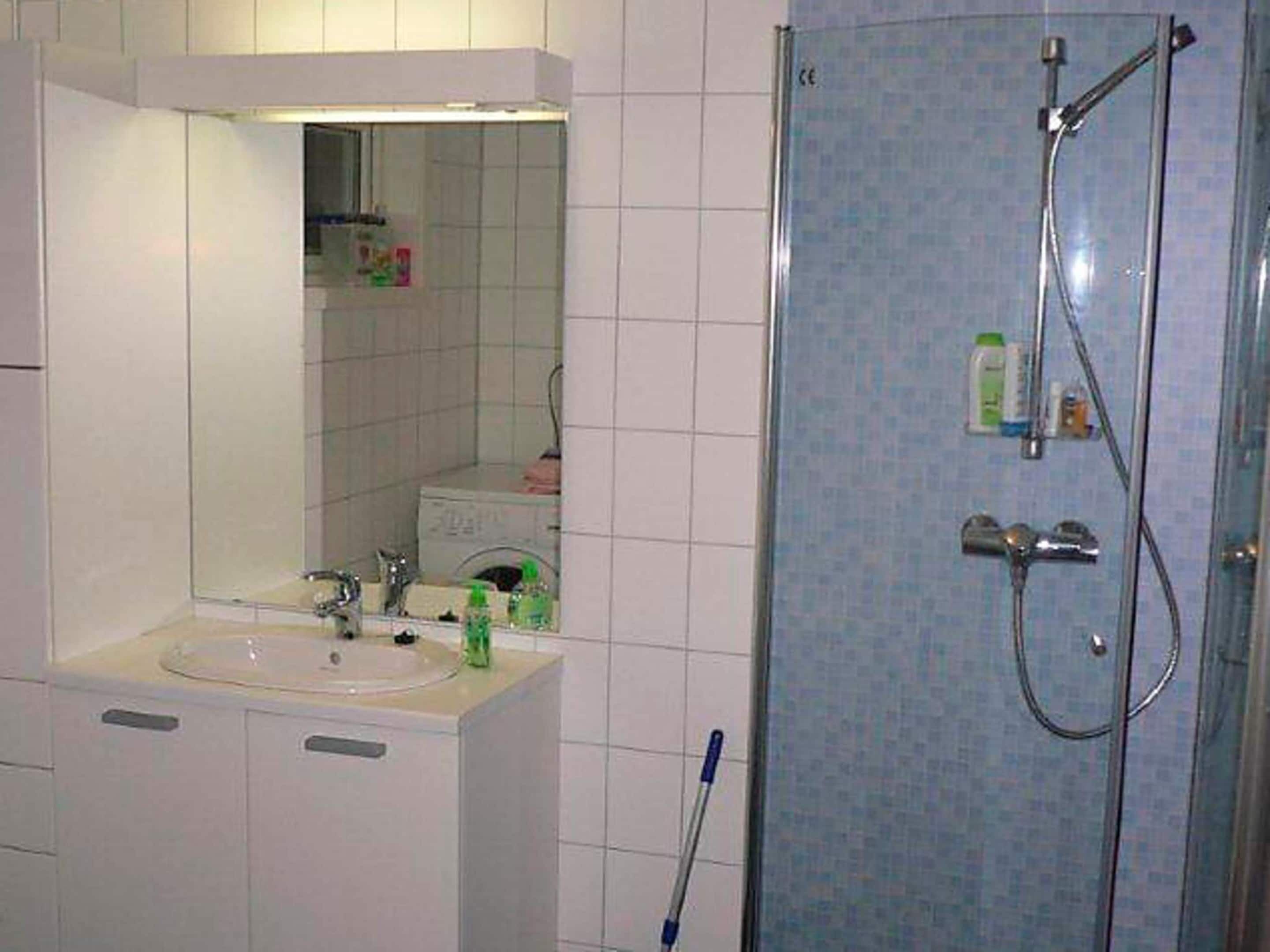 Ein Badezimmer mit Waschbecken, Spiegel und Dusche.