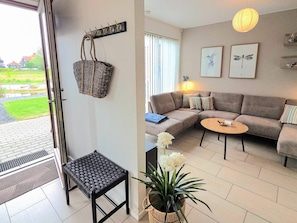 A living room with a sofa, a small table, a bench, and a potted plant. - 4 Star Holiday Home in Bogense (Bogense)