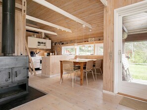 A wooden interior with a kitchen, dining area, and a large window. - 4 Star Holiday Home in Skagen (Skagen)