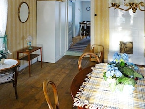 A dining area with a wooden table and chairs, a small table with a lamp, and a wall-mounted mirror. - 4 Person Holiday Home in Granna (Gränna)