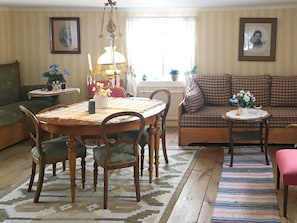 A traditional living room with a dining table, chairs, a sofa, and a patterned rug. - 4 Person Holiday Home in Granna (Gränna)