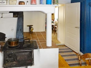 A kitchen with a stove, a sink, and a door leading to another room. - 4 Person Holiday Home in Granna (Gränna)