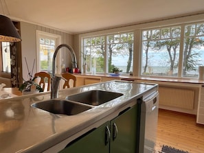 A kitchen with two sinks, a window with a view of trees, and a radiator. - Holiday Home in Mörbylånga (Morbylanga)
