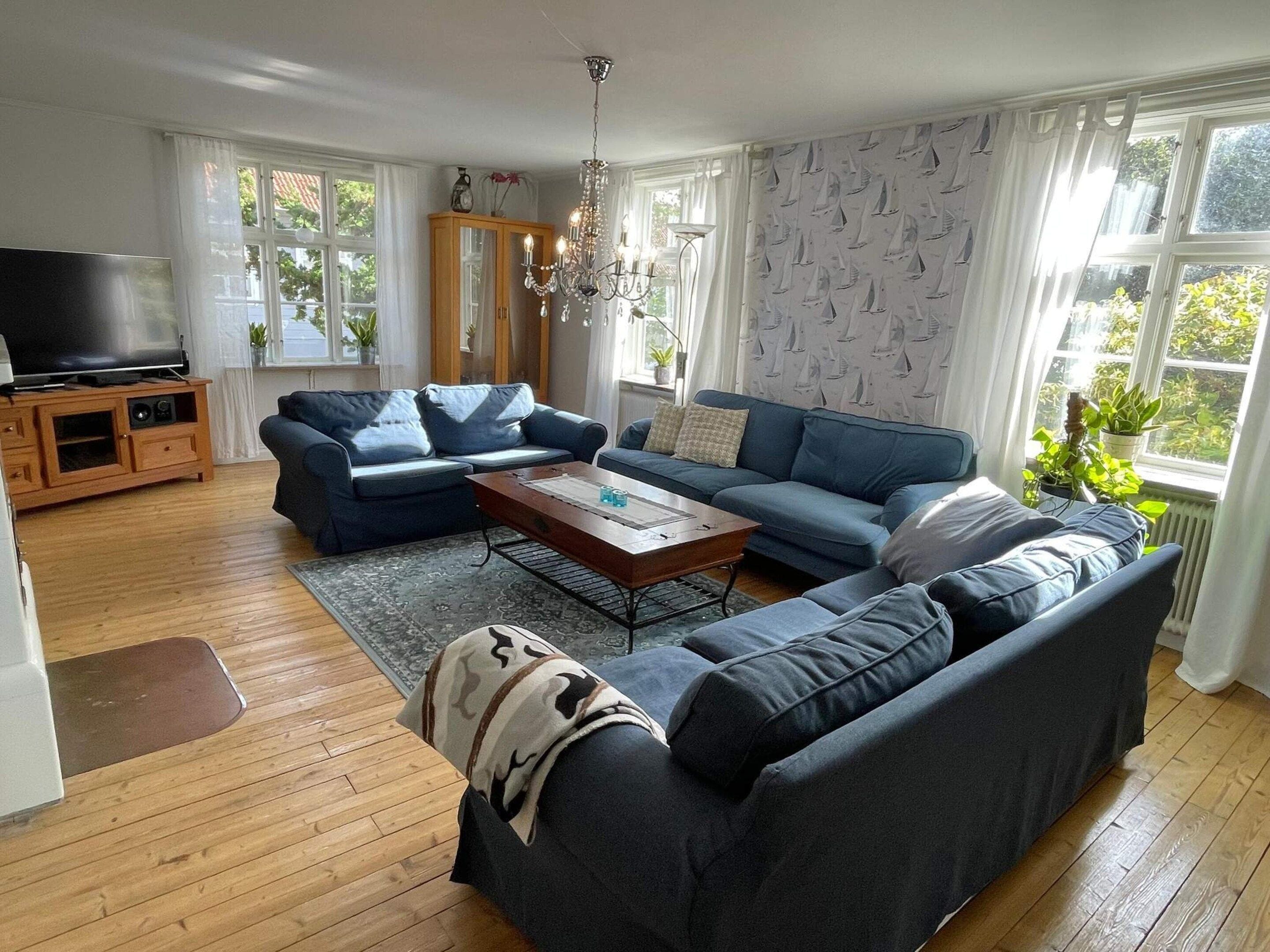 A modern living room with a sectional sofa, a wooden coffee table, and a television on a cabinet.