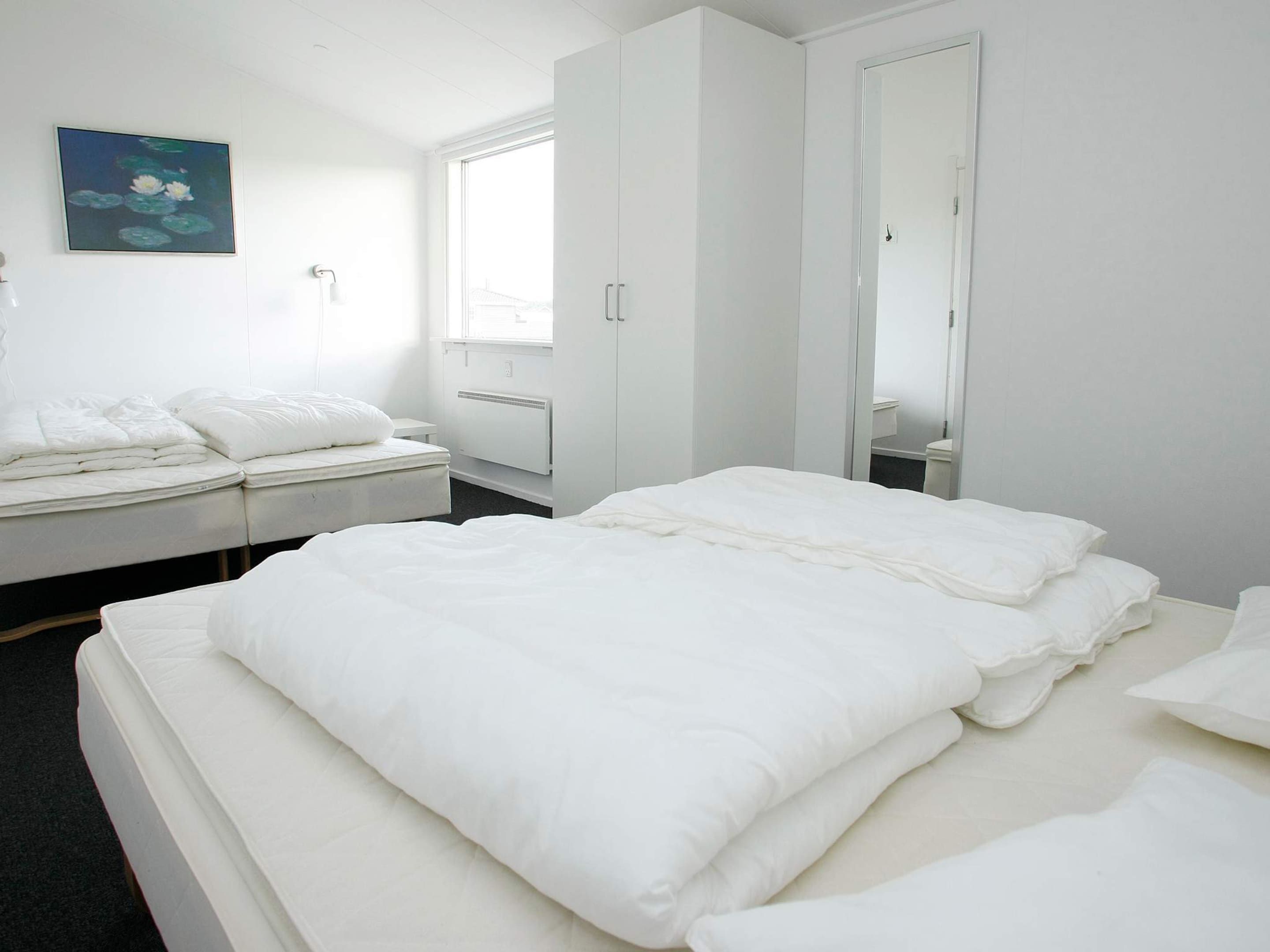 Et hotelværelse med en seng, et klædeskab, en radiator og et vindue.