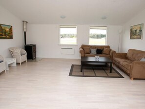 A spacious living room with a sofa, a coffee table, and a fireplace.