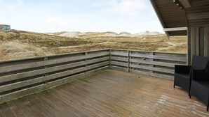 A wooden deck with a view of a dune landscape. - 4 Star Holiday Home in Ringkobing (Ringkobing)