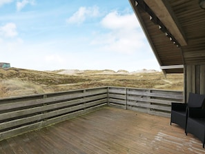 A wooden deck with a view of a dune landscape. - 4 Star Holiday Home in Ringkobing (Ringkobing)
