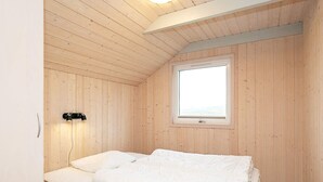 A single bed in a room with wooden walls and a sloped ceiling. - 4 Star Holiday Home in Ringkobing (Ringkobing)