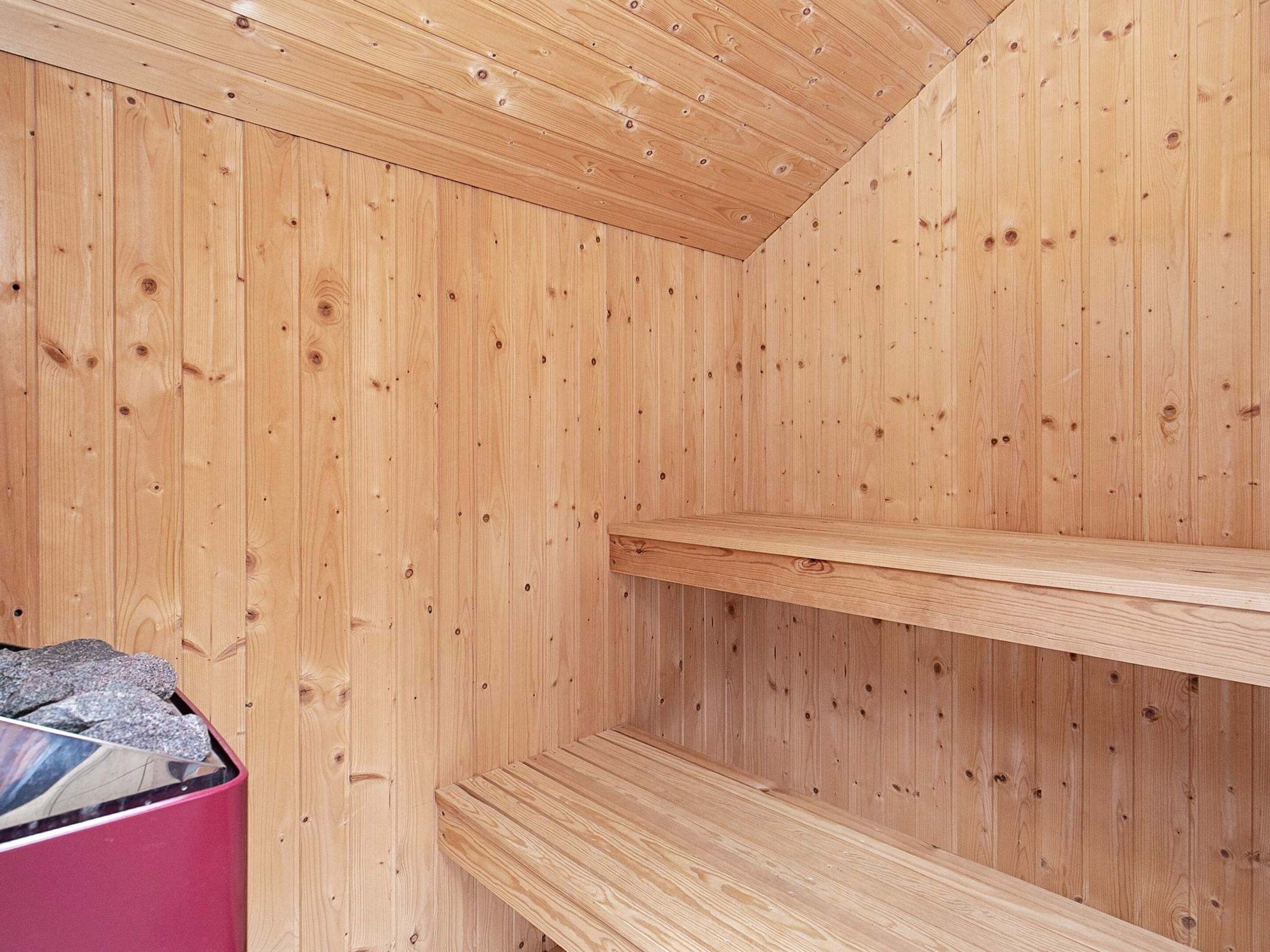 A wooden interior with a sloped ceiling and two wooden shelves.