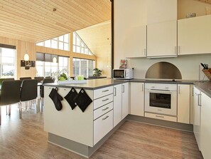 Une cuisine moderne avec des meubles en bois, un four à micro-ondes et un four encastré.