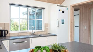 A modern kitchen with a window, stainless steel appliances, and a wooden countertop.