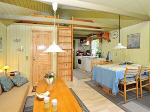 Une cuisine chaleureuse avec des meubles en bois, une table à manger avec des chaises et un îlot central.