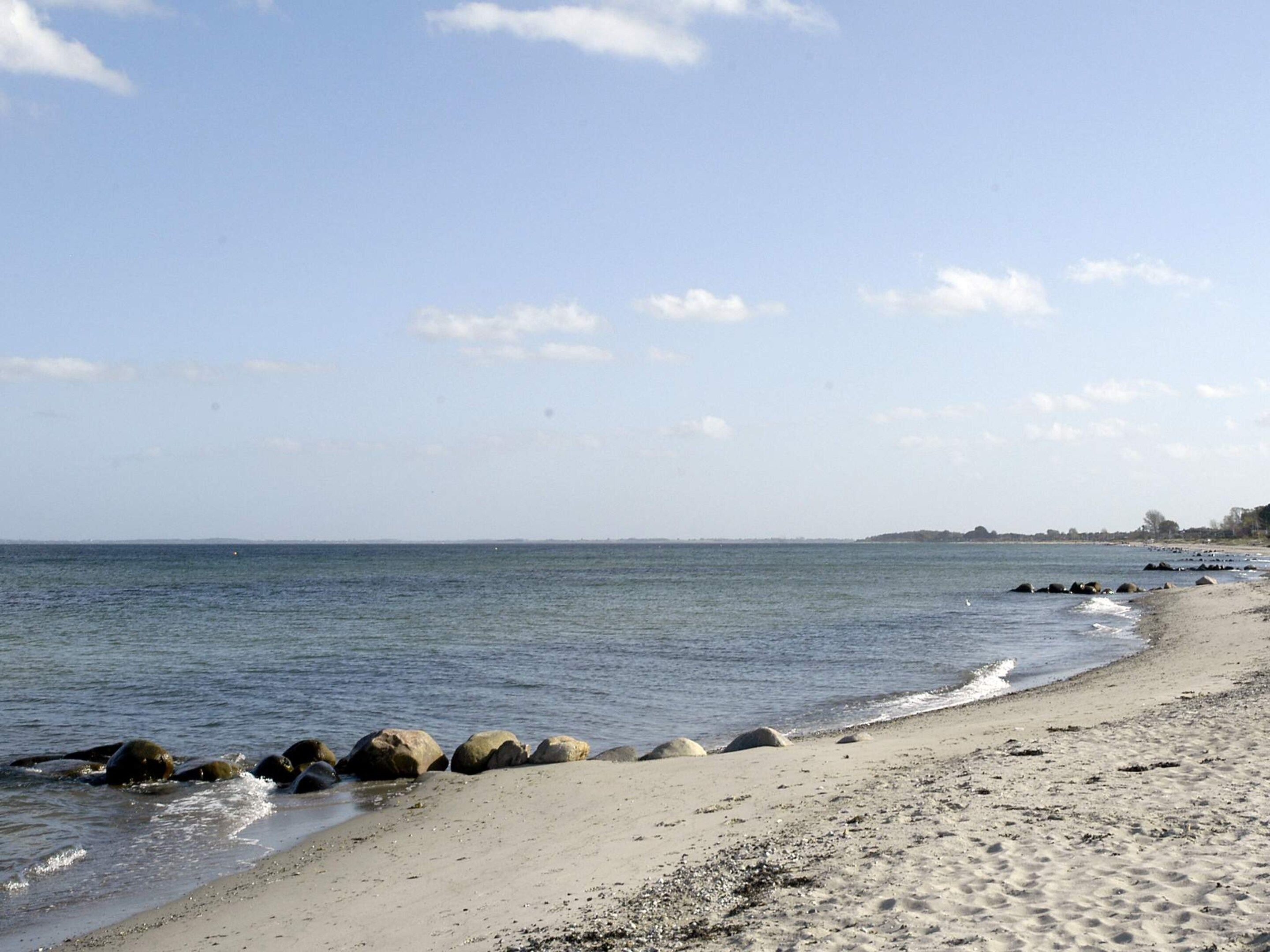 Una playa con costa rocosa y agua tranquila.