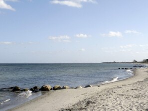 A beach with a rocky shoreline and calm water.