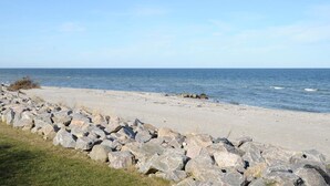 Une plage bordée d’une côte rocheuse et baignée par une mer calme.