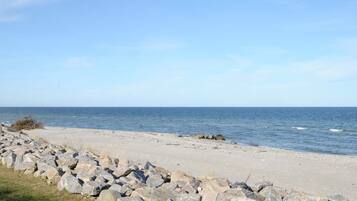 A beach with a rocky shoreline and calm sea.