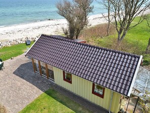 A single-story building with a tiled roof, a small porch, and a window. - Magical Holiday Home with Barbecue in Otterup near Sea (Otterup)