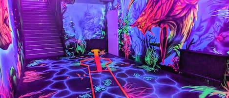 Une pièce dotée d’un sol lumineux, d’un chemin rouge et d’une fresque représentant un dragon.