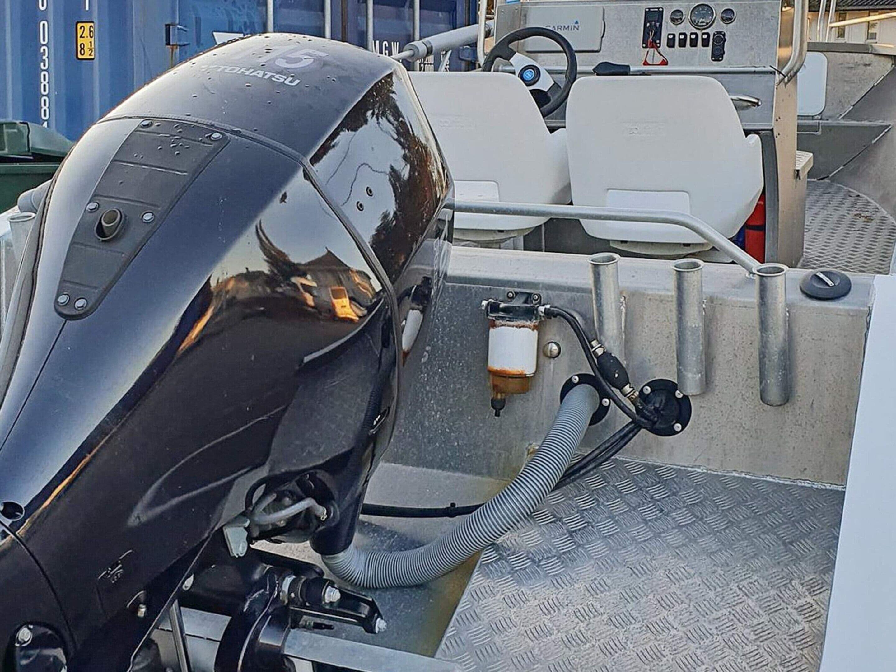 A boat's engine and control panel with visible gauges and a steering wheel.