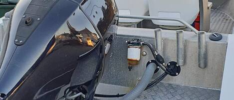 A boat's engine and control panel with visible gauges and a steering wheel.