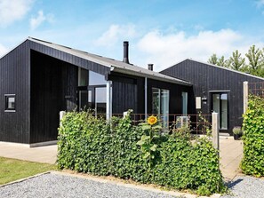 A modern two-story building with a dark exterior, large windows, and a visible chimney. - 5 Star Holiday Home in Haderslev (Haderslev)