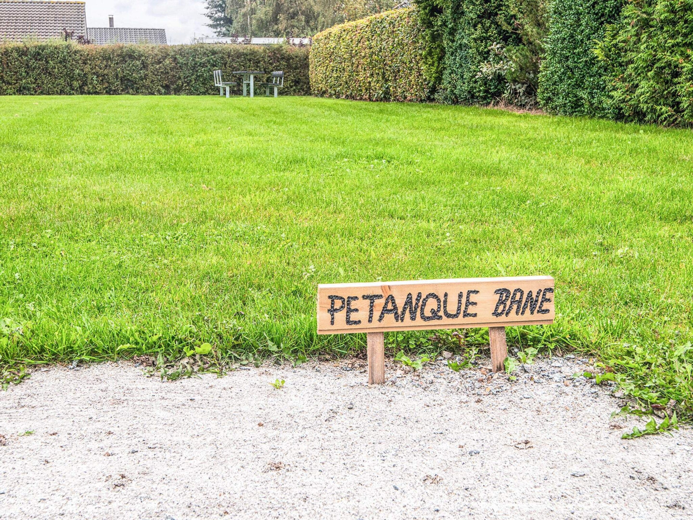 A sign reading 'PETANQUE BRANE' on a gravel path.