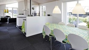 A modern kitchen with white cabinets, a central island, and pendant lighting. - 5 Star Holiday Home in Haderslev (Haderslev)