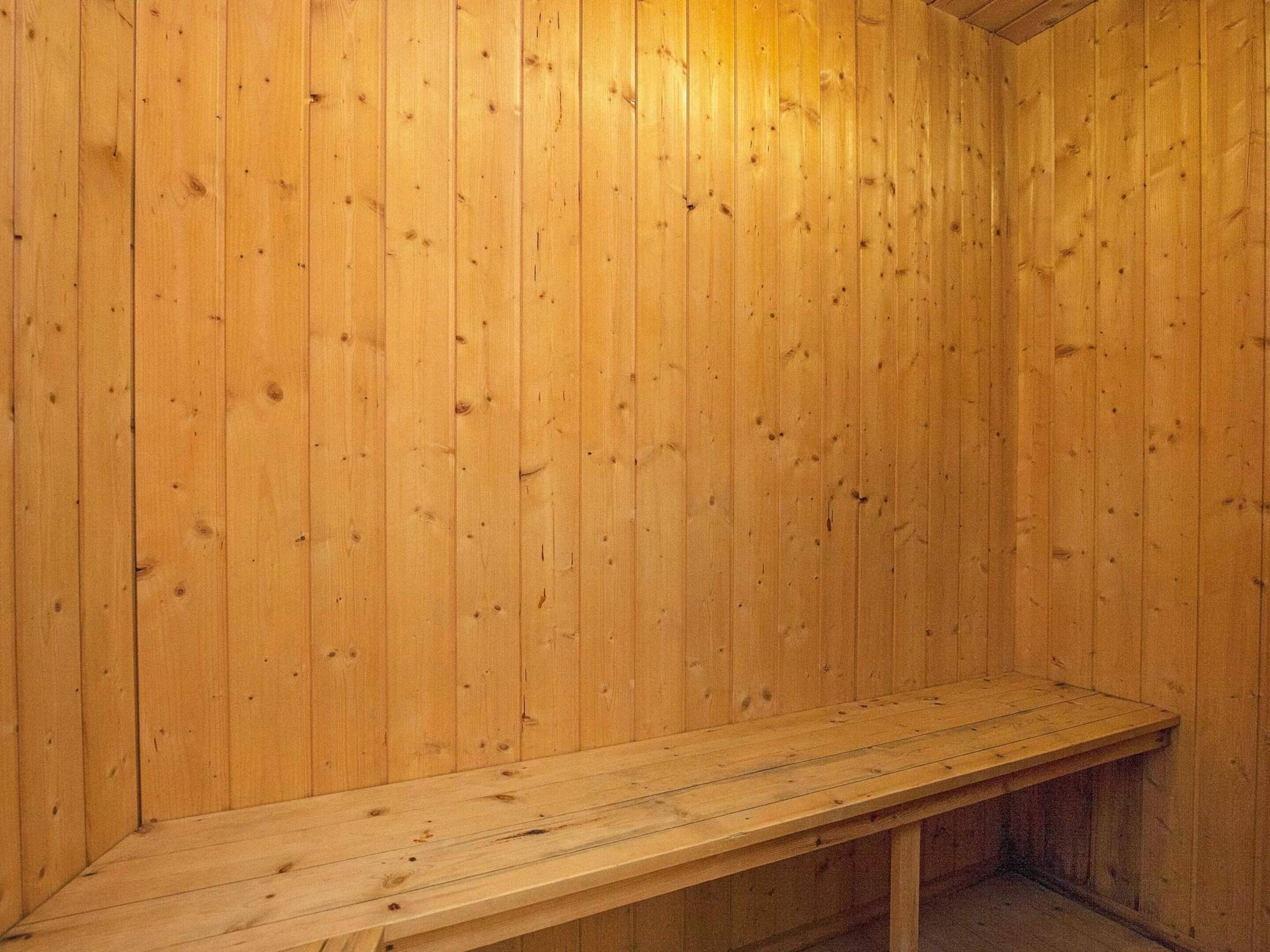 Uma sauna de madeira com um banco.