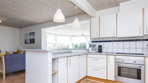 A modern kitchen with white cabinets, a built-in oven, and a coffee maker. - Spacious Holiday Home in Hemmet Jutland near Sea (Hemmet)