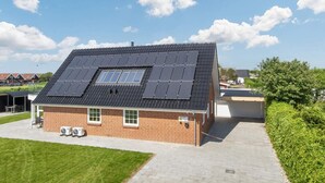 A single-story house with a sloped roof, solar panels, and a covered patio area. - Spacious Holiday Home in Hemmet Jutland near Sea (Hemmet)