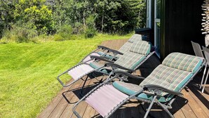 Une terrasse dotée de quatre chaises longues à structure métallique et à assise rembourrée.
