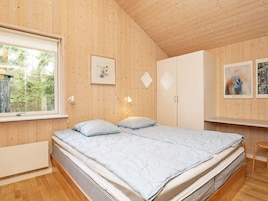 Una habitación con cama, armario, escritorio y ventana.