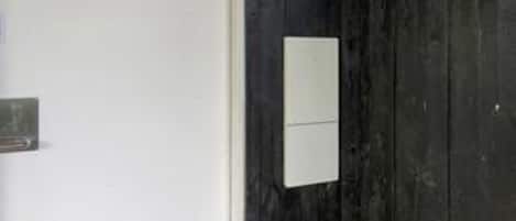 Uma porta com um painel branco e um pequeno objeto retangular sobre ele.