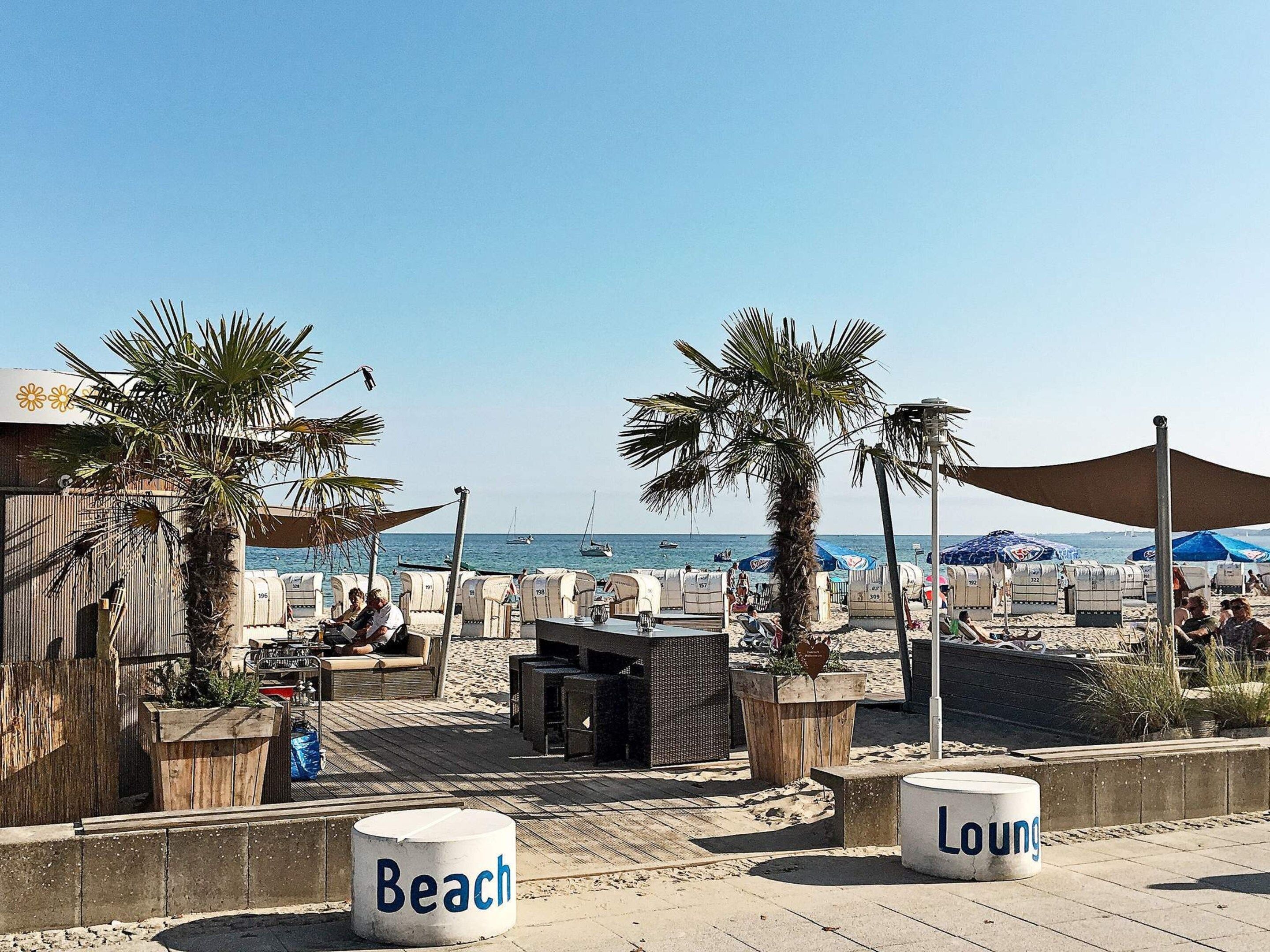 A beachside lounge area with seating and a view of the sea.