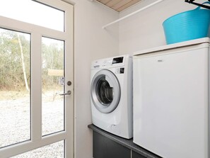 A laundry area with a washing machine and a refrigerator.