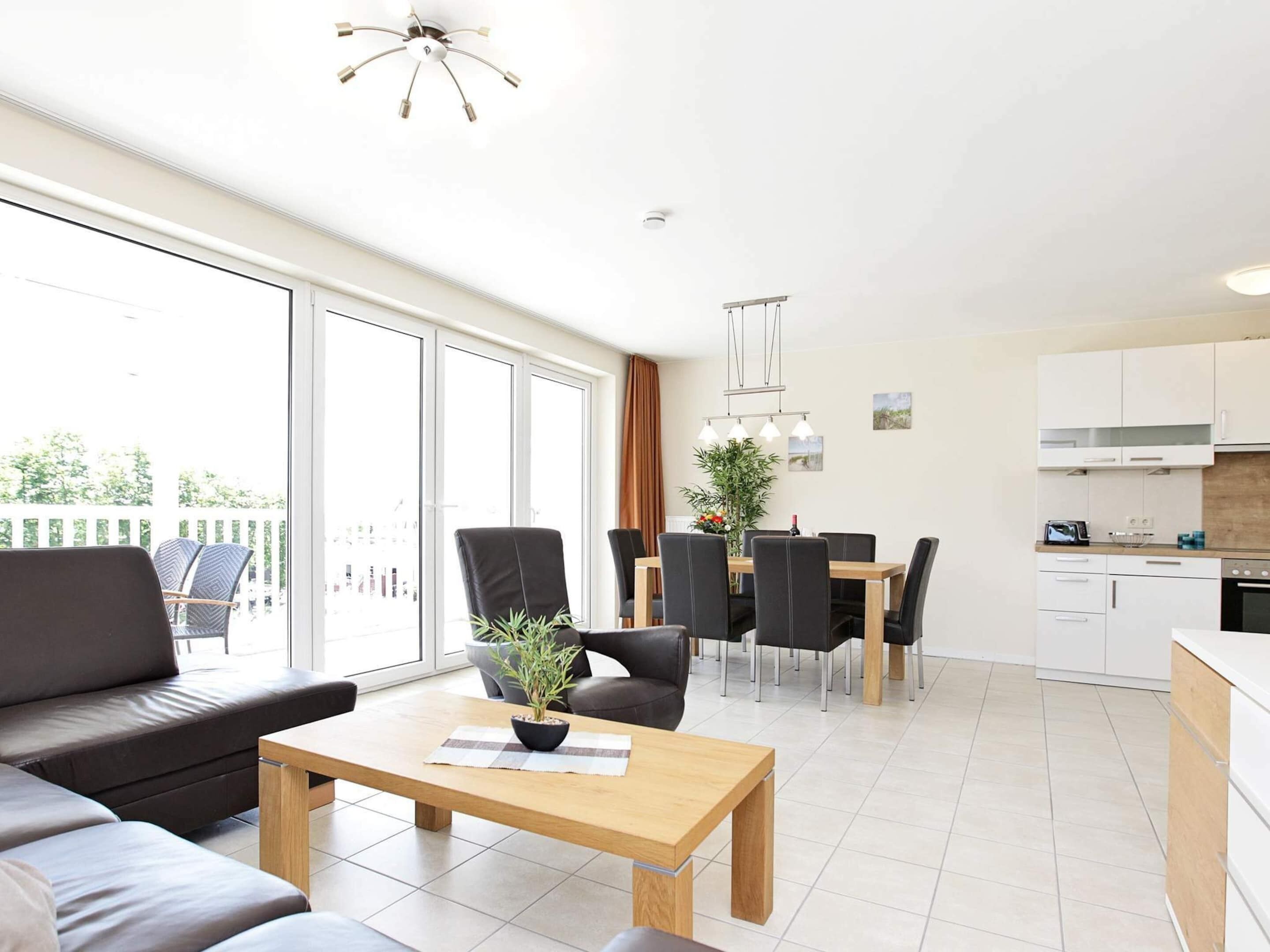 Eine moderne Wohnung mit Essbereich, Küche und einem Balkon mit Gartenmöbeln.